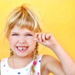 Girl with a tooth in her hand