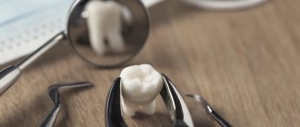 Зуб перед зеркальцем стоматолога